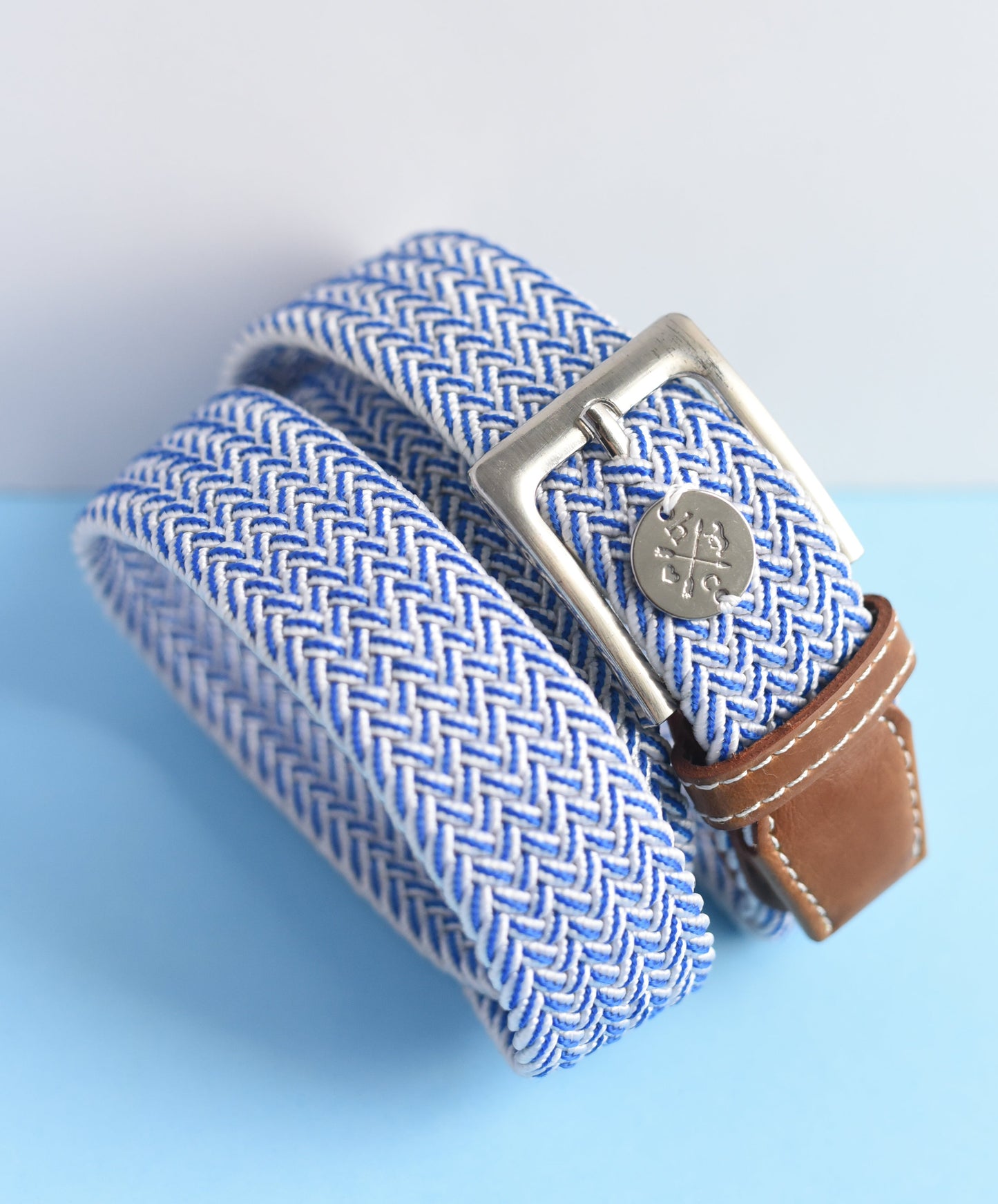 Blue and white striped belt with a brown strap on a light blue background